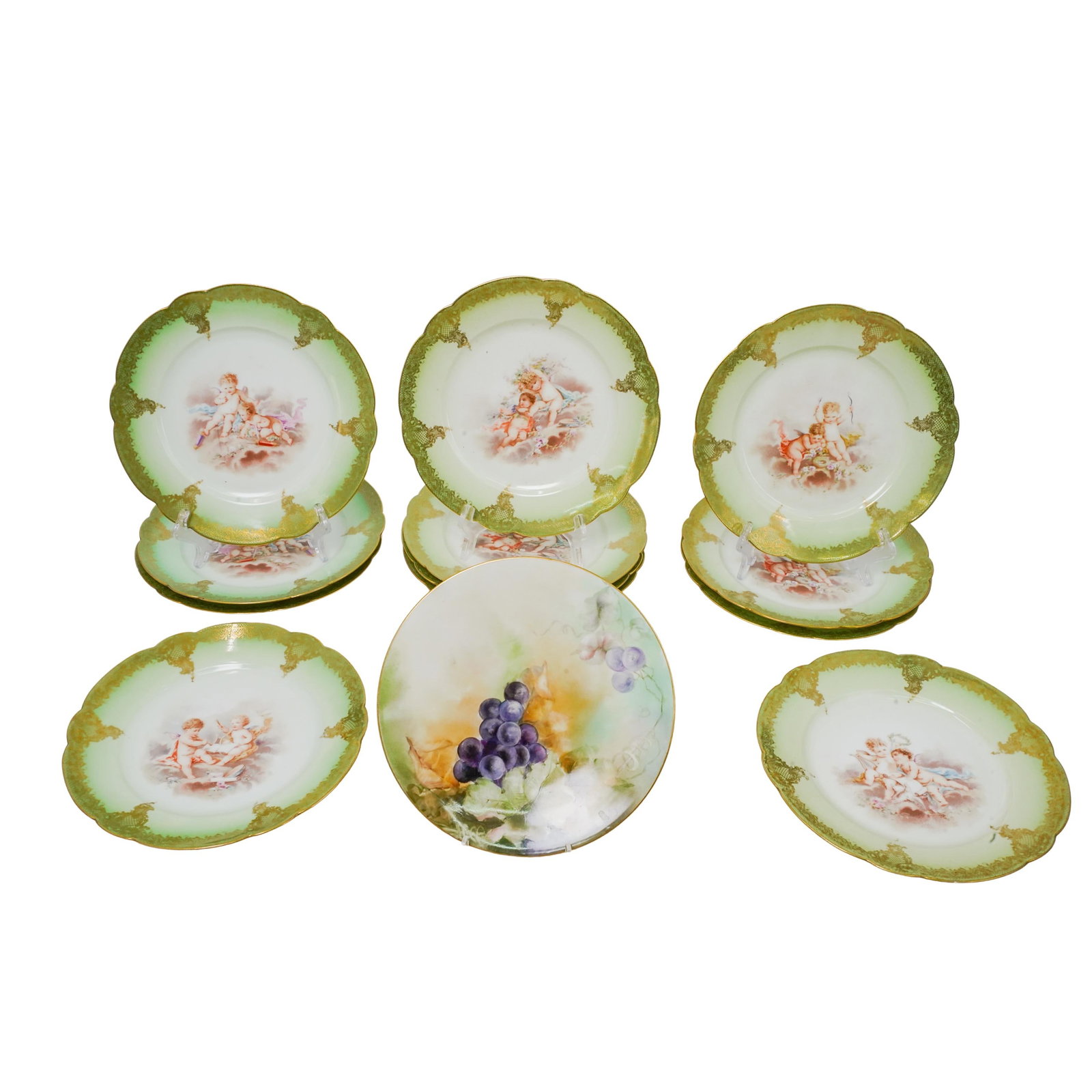 (13 Pc) R. Delinieres & Limoges Porcelain Plates: DESCRIPTION: This is a collection of porcelain plates. Each plate features a central illustration of cherubs. The edges have a green gradient that fades toward the center, complemented by gold detaili