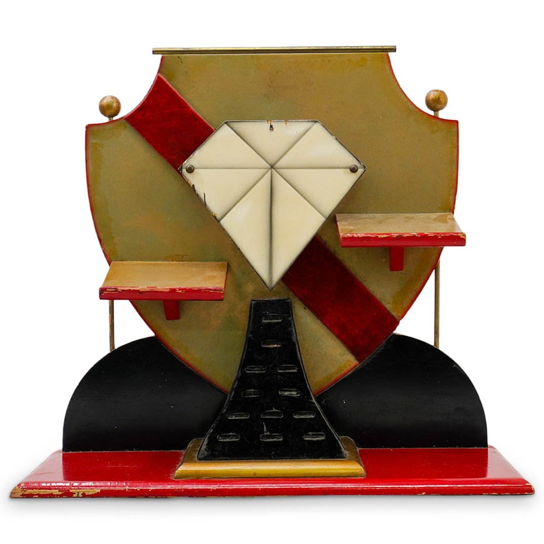 19th Century Jewelry Display: DESCRIPTION: 19th century display for jewelry. Wooden construction painted with red, black, and gold accents. Felt ring display holders. Diamond emblem in the center features a light behind it to crea