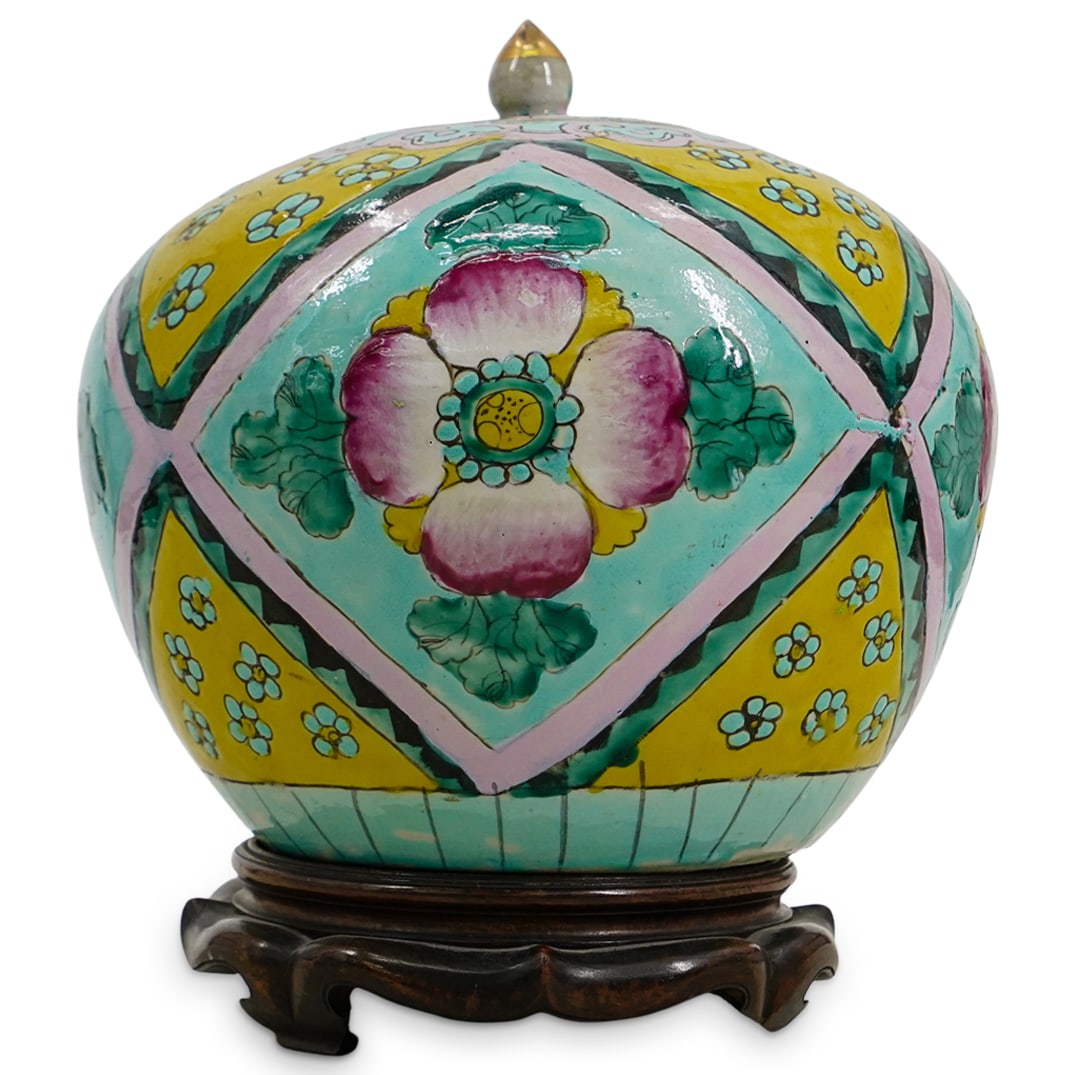 Antique Chinese Enameled Porcelain Ginger Jar: DESCRIPTION: Antique Chinese porcelain ginger jar, featuring a bulbous form with hand painted enameled geometric pattern incorporating florals throughout. The ginger jar sits atop a carved wood stand.