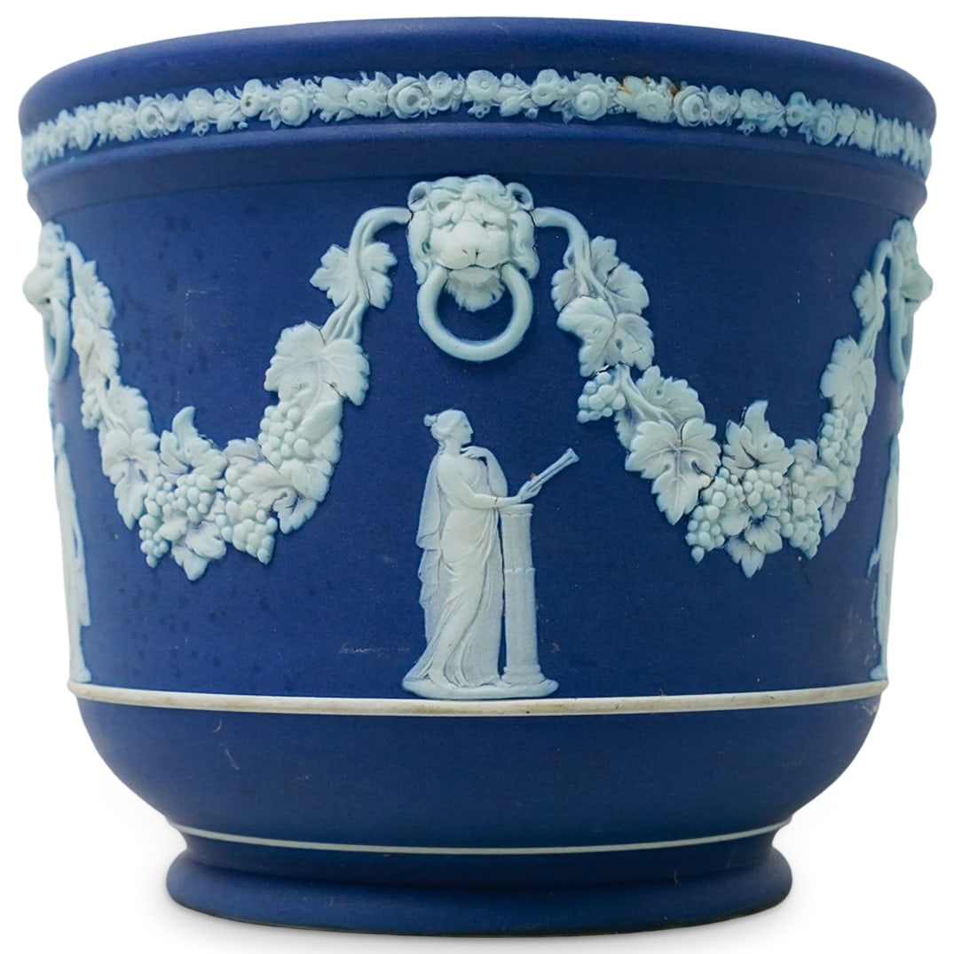 Wedgwood Jasperware porcelain Planter: DESCRIPTION: Iconic "Wedgwood blue" jasperware planter. Features white detail of classical elements like grapevines, lion door knockers, and female robed figures. Marked "Wedgwood" on the bottom of th
