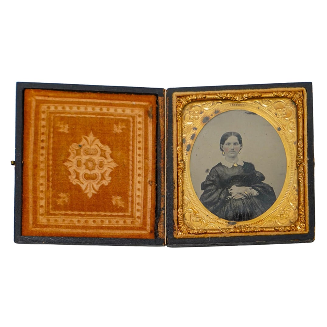 Antique Ambrotype Portrait Of A Pregnant Woman: DESCRIPTION: Antique ambrotype portrait in a gutta percha case, depicting a seated pregnant woman, wearing a long dark colored dress with a white ruffled collar. There is gold overpaint on her jewelry
