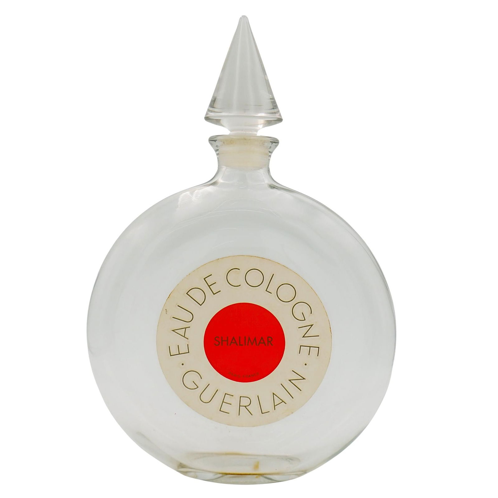 Vintage Guerlain Shalimar Cologne Bottle: DESCRIPTION: The bottle is large, round, and made of clear glass with a minimalist design. It features a conical glass stopper. The front label reads "EAU DE COLOGNE – GUERLAIN," encircling a vibran