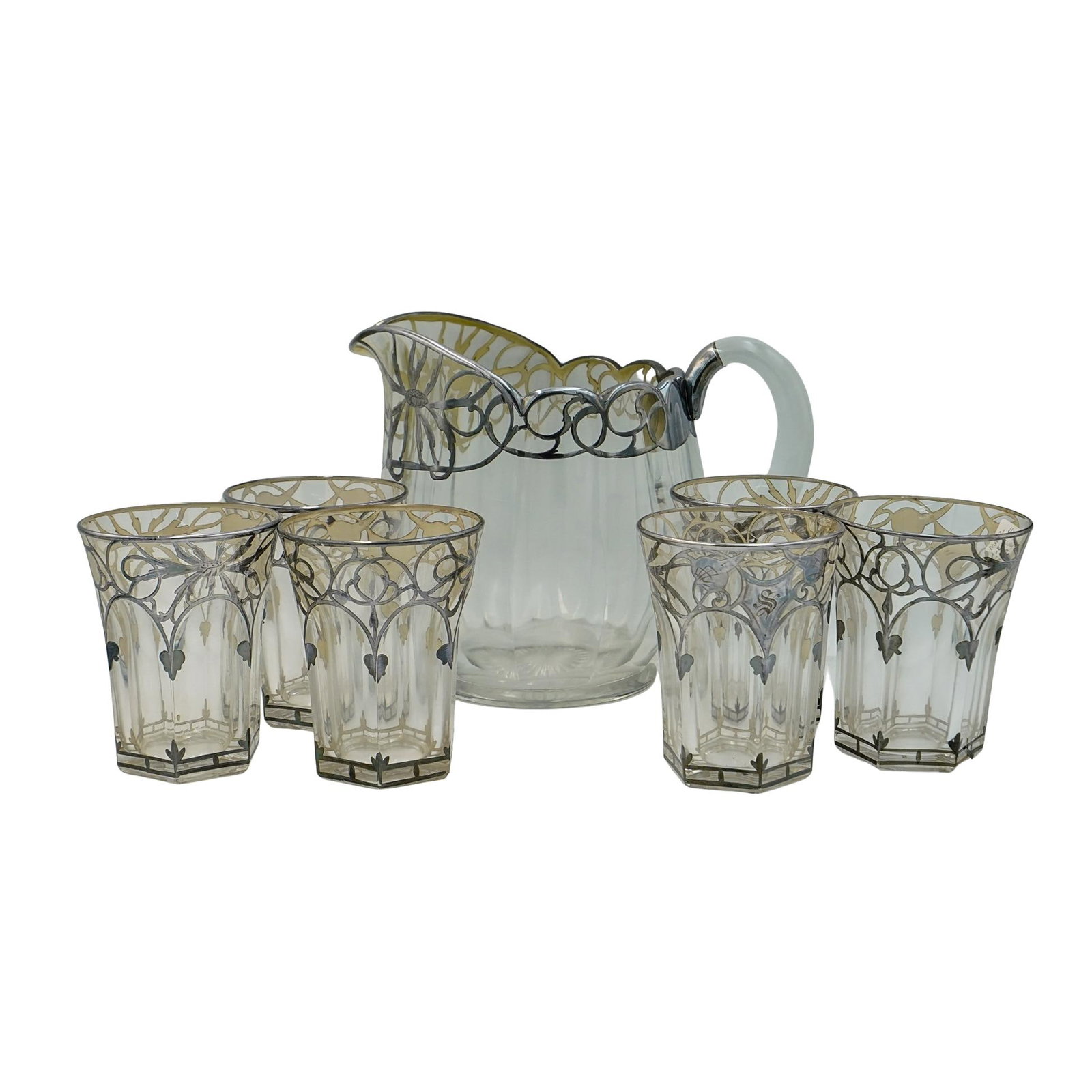 Vintage Heisey Silver Overlay Glass Collection: DESCRIPTION: This is an antique glass pitcher and tumbler collection with a sterling silver overlay. This collection consists of: (1 Pc) Pitcher Made of clear glass with a scalloped rim and a curved s