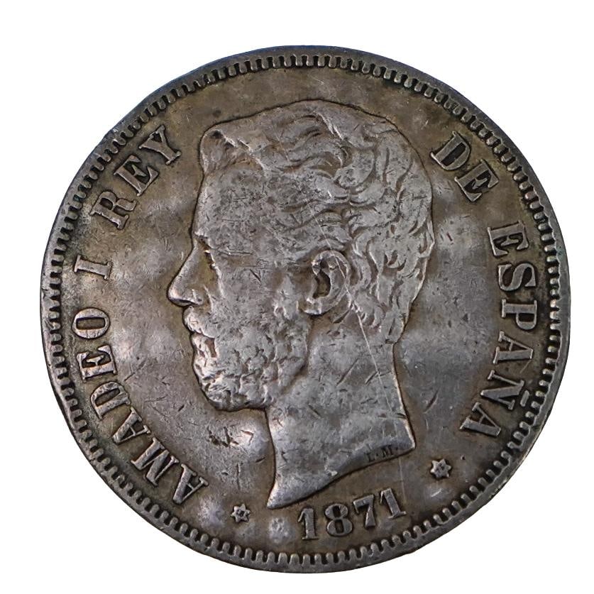 Spanish King Amadeo I 5 Pesetas Coin (1871): DESCRIPTION: Spanish 5 pesetas coin 1871 featuring King Amadeo I. Features a carved depiction of King Amadeo I. Back marked with Spanish fleet names and July 3 1898. CIRCA: 19th century ORIGIN: Spain 