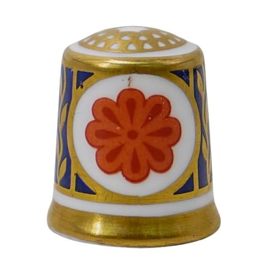 Royal Crown Derby 24 KT Gold Imari Porcelain Sewing Thimble: Royal Crown Derby 24 KT Gold Imari Porcelain Sewing ThimbleLate 20th Century, EnglandRoyal Crown Derby porcelain sewing thimble, featuring 24k gold leaf detail with a central orange floral medallion.