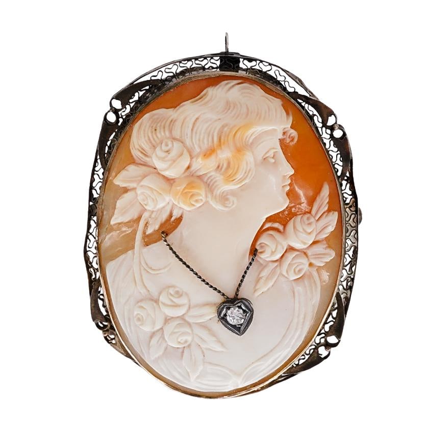 Antique Mixed Metal Cameo with Inset Stone: Antique Mixed Metal Cameo with Inset StoneLate 19th to early 20th century, ContinentalAntique carved shell cameo featuring a female depiction with floral elements. The cameo is inset with a clear ston