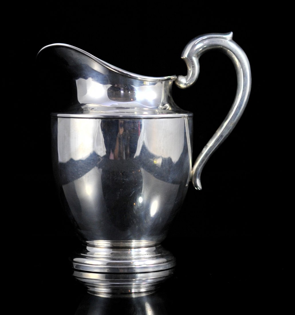 Large sterling Art Deco style water pitcher. Hallmarked: DESCRIPTION: Large sterling Art Deco style water pitcher. Simple elegant lines with a step design base. Fat body with an Art Deco arched handle and wide spout. Solid sterling, not weighted. Stamped on