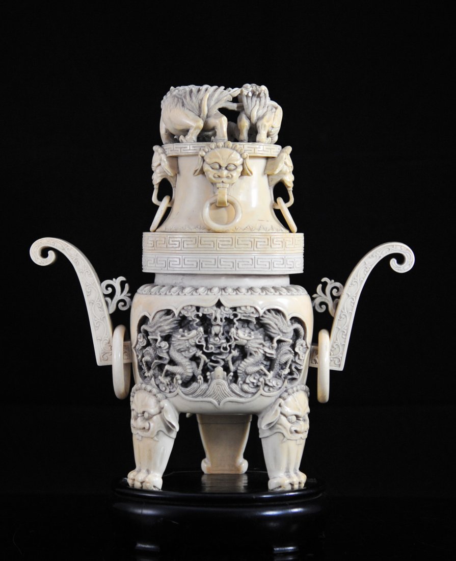 Large 19th Century hand carved Chinese ivory urn: DESCRIPTION: 19th Century hand carved Chinese ivory urn. Large triple footed hand carved ivory urn featuring foo dog faces and legs as the feet. The main body contains two separate deep relief hand ca