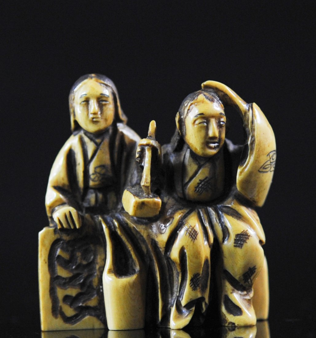 Antique Chinese double figure ivory netsuke. Signed: DESCRIPTION: Antique Chinese double figure ivory netsuke. Hand carved scene of two robed women sitting side by side. One holds a block while the other writes on it. Deep carving with a superb patina. 