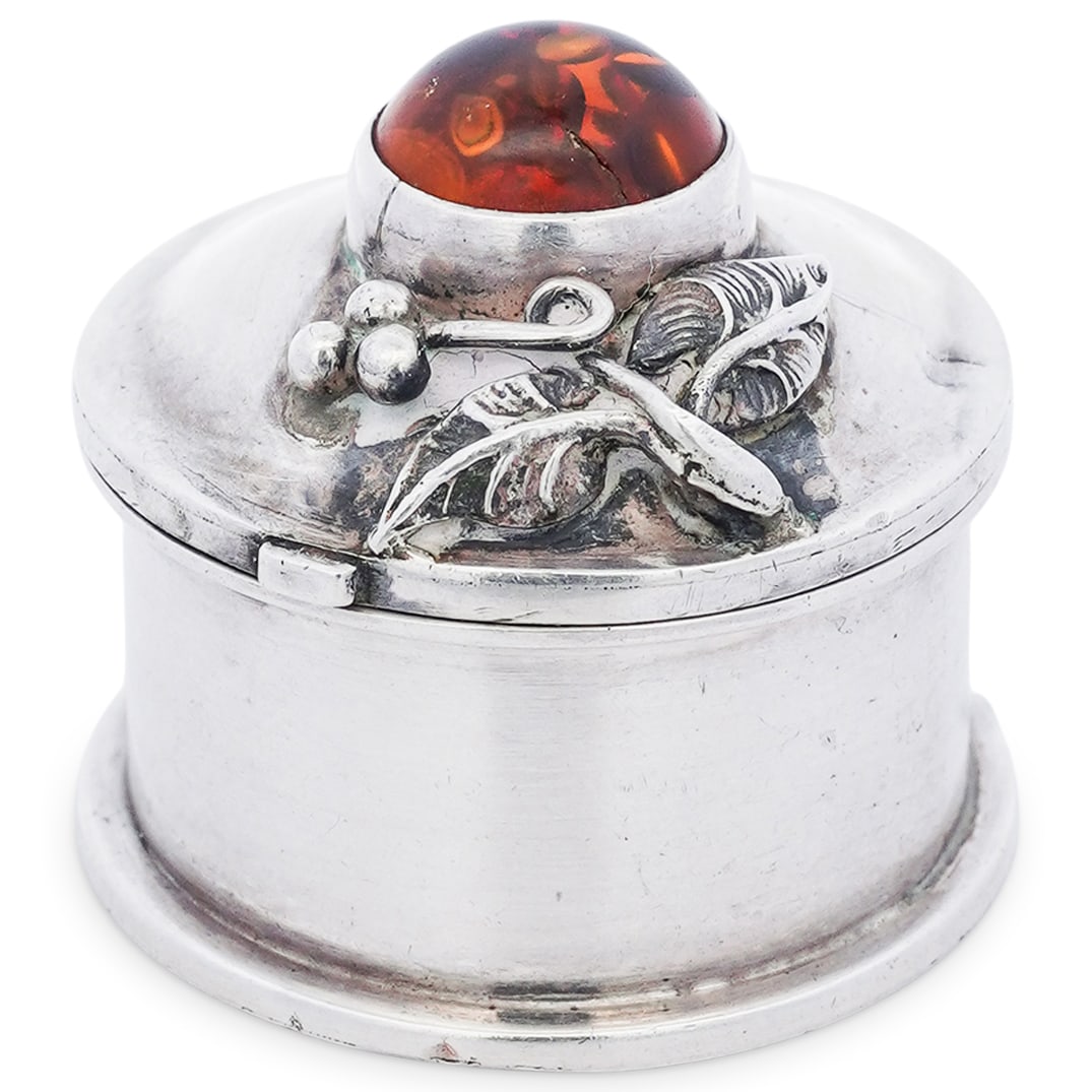 Sterling Silver Pill Box with Amber: Sterling Silver Pill Box with Amber20th centuryRound sterling silver pill box featuring a floral motif on the lid and a polished amber stone at the center. It is marked and stamped "925". Total weight