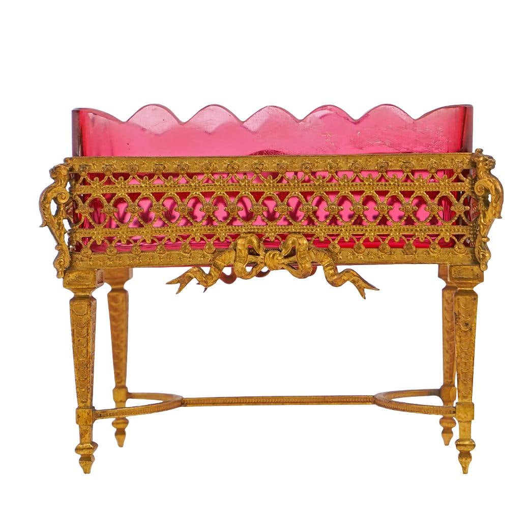 Antique Empire Ormolu and Cranberry Glass Vanity Dish: Antique Empire Ormolu and Cranberry Glass Vanity DishLate 19th-early 20th century, FrenchAntique French empire-style ormolu brass and cranberry glass vanity dish. Footed on tall legs. Scalloped-cut ri
