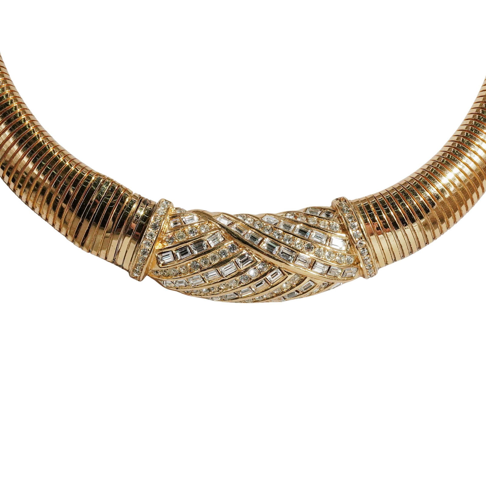 Christian Dior Gold Tone Omega Choker Necklace: Christian Dior Gold Tone Omega Choker Necklace20th c., FranceRibbed flexible gold metal choker necklace set with clear round and baguette-cut rhinestones. Christian Dior hallmark on the clasp and CD c