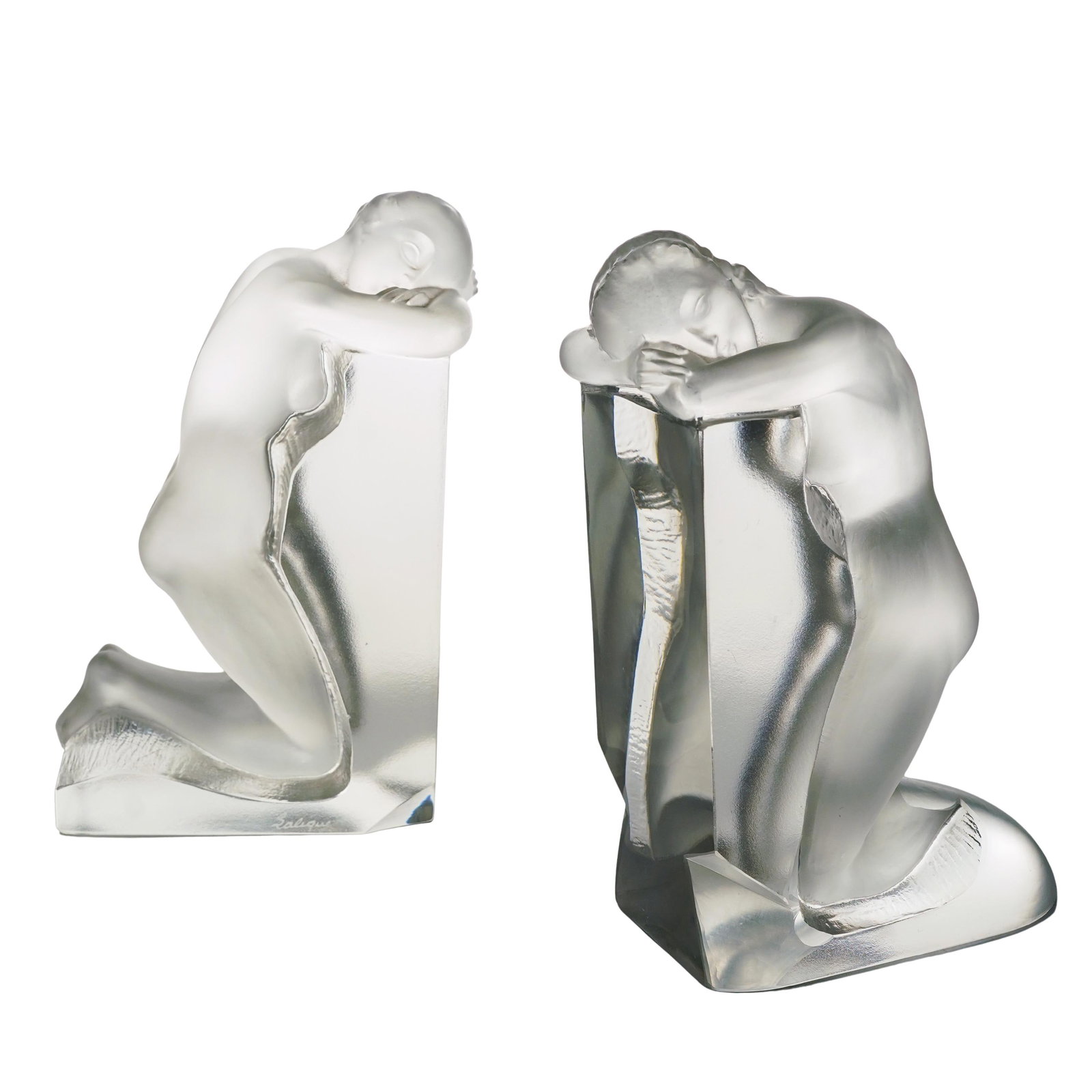 Lalique Crystal "Reverie" Figural Bookends: Lalique Crystal "Reverie" Figural Bookends 20th Cent., Francia Lalique crystal "Reverie" figural bookends in clear frosted crystal depicting a pair of kneeling female nude figures. Signed "Lalique Fra
