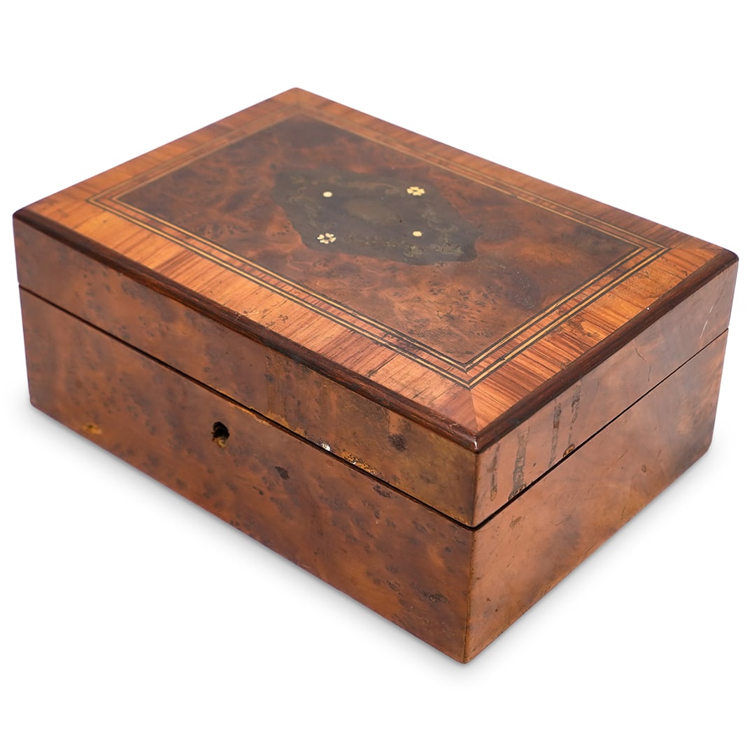 Antique French Burl and Walnut Inlay Jewelry Box: Antique French Burl and Walnut Inlay Jewelry Box19th c., FranceCarved wood box featuring an inlaid floral pattern with brass and bone on the lid and quilted silk lining the interior.H: 3.75" W: 6.25"