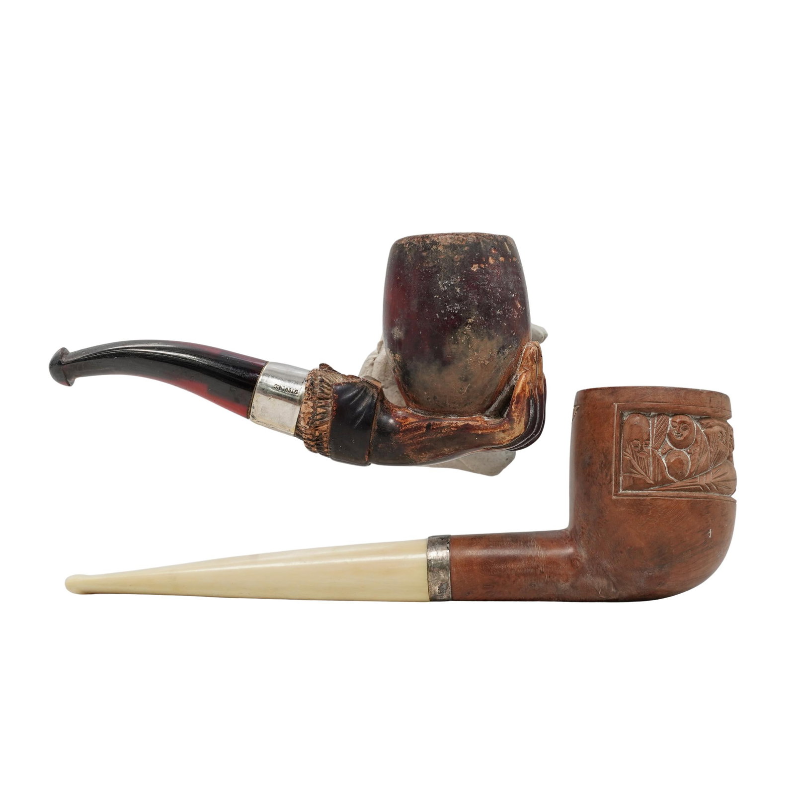 (2 pcs) Antique Briar and Silver Tobacco Pipes: (2 pcs) Antique Briar and Silver Tobacco Pipes late 19th-early 20th century, Continental A set of two antique tobacco pipes. Smaller pipe is carved to look like a hand grasping the bowl, and has a ste
