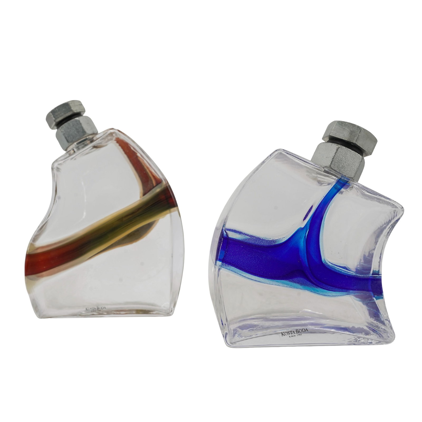 Pair of Kosta Boda Art Glass 'Macho' Decanters: Pair of Kosta Boda Art Glass 'Macho' Decanters2000, SwedenPair of Kosta Boda art glass 'Macho' decanters, featuring distinct tilted block form, colorful linear decor, and a bolt shaped lid. Singed und