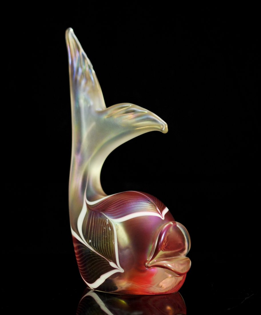 Stuart Abelman cranberry art glass fish. Signed: DESCRIPTION: Stuart Abelman cranberry art glass fish. Abstract art glass fish with a cranberry body hue. Features a symmetrical design towards the base with a large tail extended above it's head. Irid