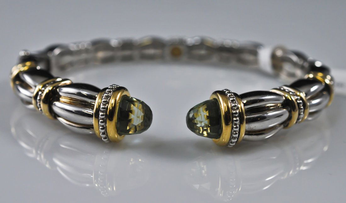 Nisso Barokas sterling, 18k and citrine bracelet: DESCRIPTION: Nisso Barokas sterling, 18k and citrine bracelet. Features two faceted cabochon citrine stones at each end. Sterling body with 18k accent. Stamped SV925 18k. 37 grams CIRCA: Late 20th Cen