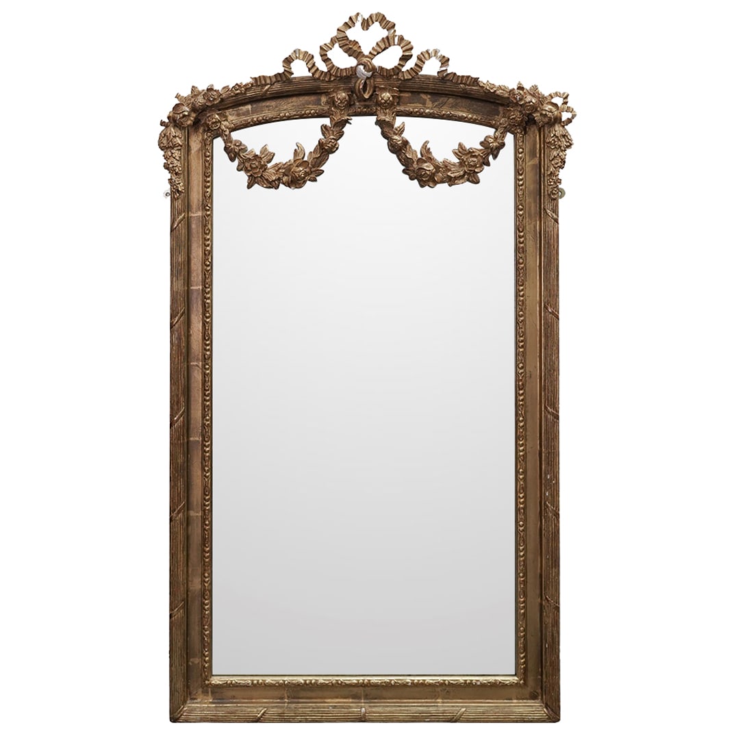 Antique French Louis XVI Gilt Wood Mirror: Antique French Louis XVI Gilt Wood Mirror1880-1889, France.Antique French Louis XVI style hand carved gilt wood mirror, modeled in hand carved wood with garlands and ribbons of flowers, further enhanc