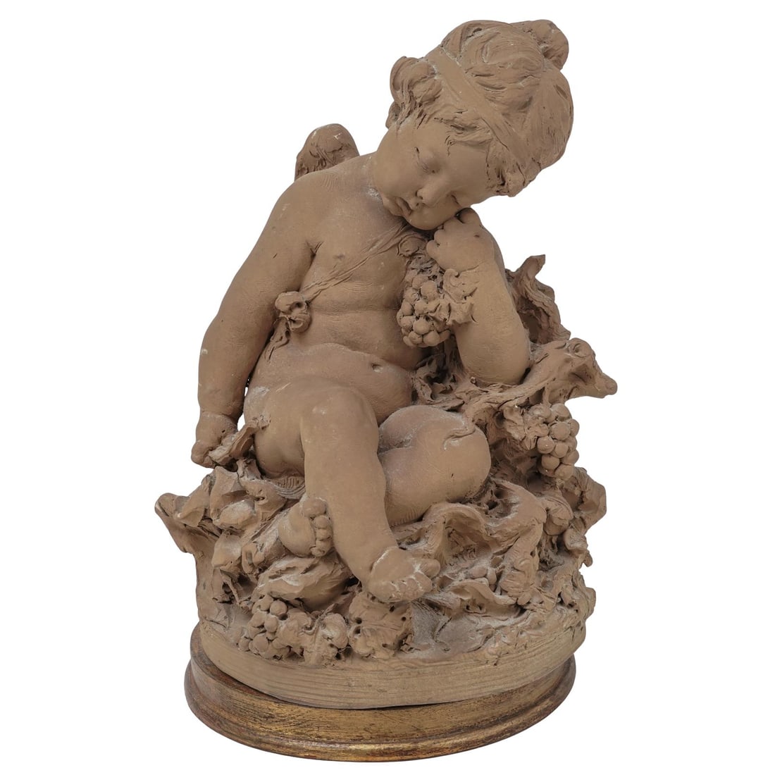 Moreau Style Terracotta Cherub Sculpture: Moreau Style Terracotta Cherub Sculpture Late 19th-early 20th century, Europe A Moreau-style terracotta sculpture of cherub, sleeping among carved grape vines and foliage. Gilt wood base. H 14" Diamet