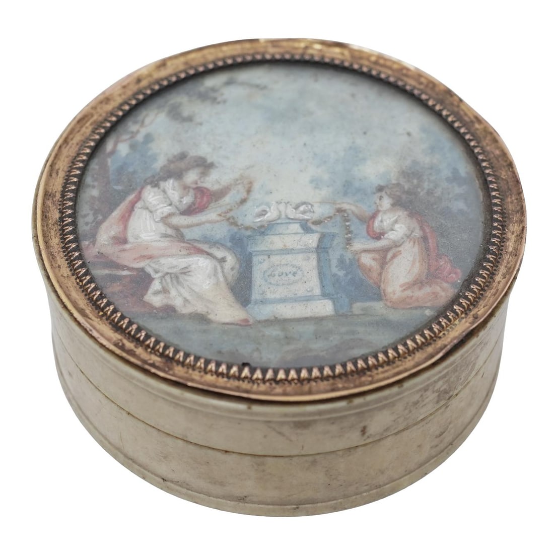 Antique Hand Painted Carved Bone Pill Box: Antique Hand Painted Carved Bone Pill BoxLate 19th-early 20th century, ContinentalAn antique carved bone pill box with hand-painted Neoclassical scene of two women decorating a pedestal with "love" wr