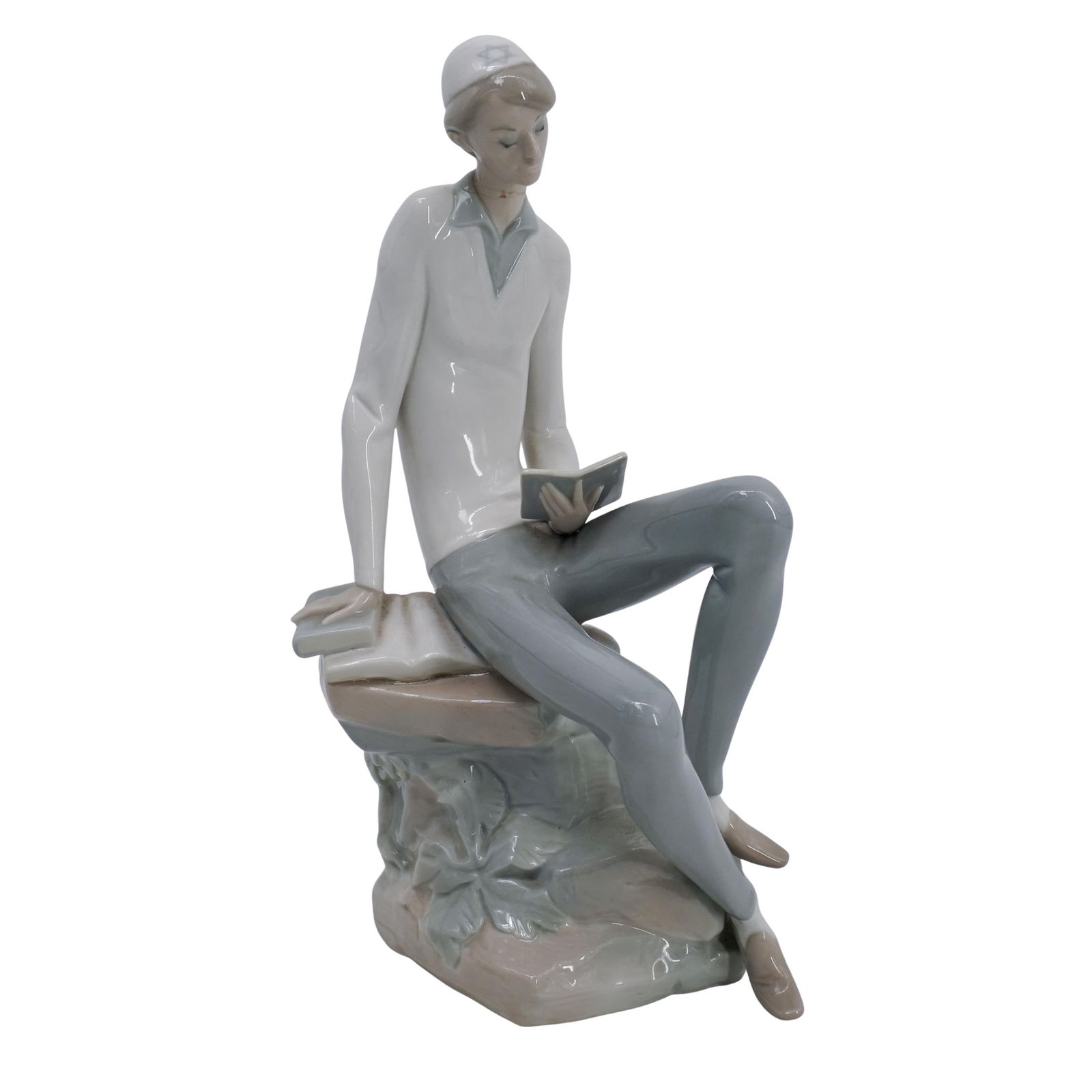 Lladro "Hebrew Student" Porcelain Figurine: Lladro "Hebrew Student" Porcelain FigurineMid 20th Cent.SpainA glazed porcelain figurine depicts a young Jewish student sitting in serene contemplation, absorbed in a book. The figure, sculpted with a