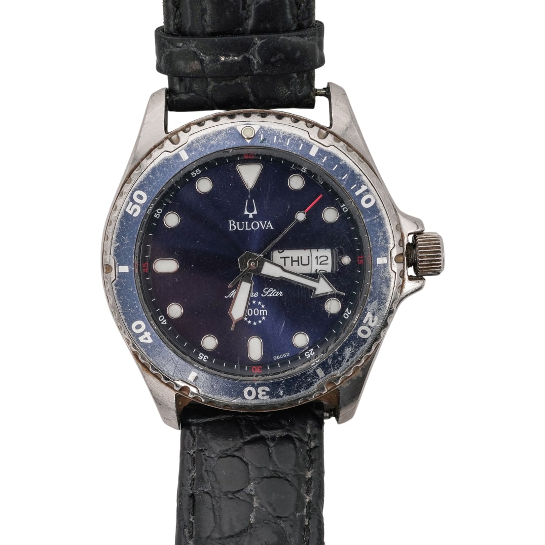 Bulova Stainless Marine Star Watch: Bulova Stainless Marine Star Watch20th c., SwissBulova stainless steel watch featuring a rotating blue bezel and blue dial with a day-date display and luminous hands. It has a black leather band, uses