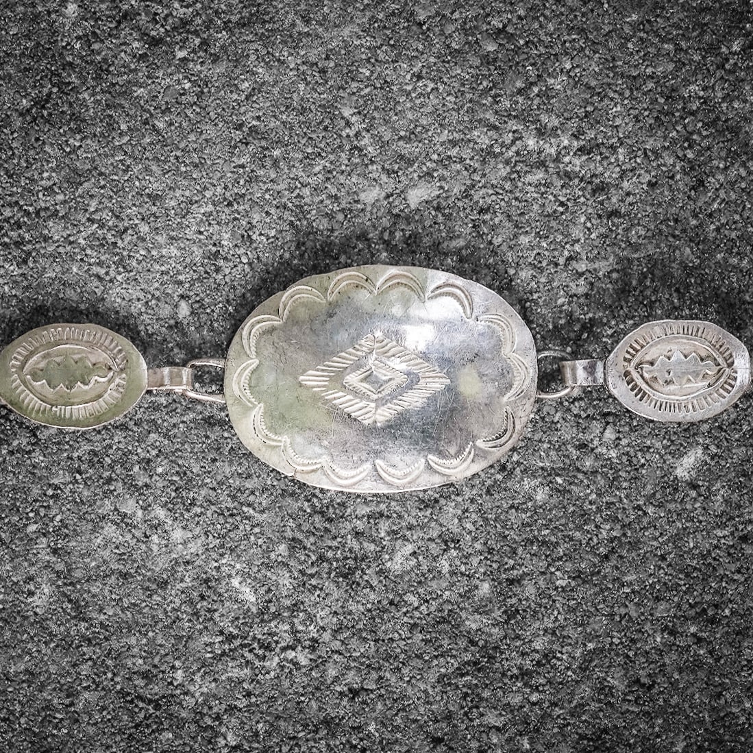 Vintage Navajo Sterling Silver Stamped Concho Belt: Vintage Navajo Sterling Silver Stamped Concho Belt Circa 1970s–1980s, USA. Handcrafted Navajo sterling silver concho belt featuring a series of oval and round stamped conchos connected with handmade