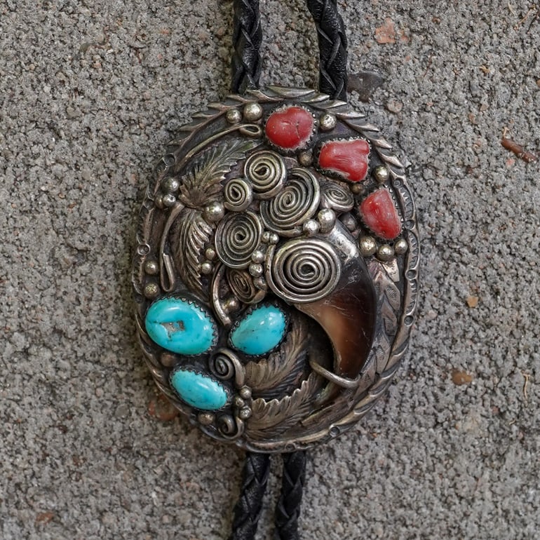 Stamped Navajo Sterling Silver Turquoise, Coral & Bear Claw Bolo Tie: Stamped Navajo Sterling Silver Turquoise, Coral & Bear Claw Bolo Tie Circa 1960s–1970s, USA Navajo sterling silver bolo tie featuring a natural bear claw accented by turquoise cabochons and branch c