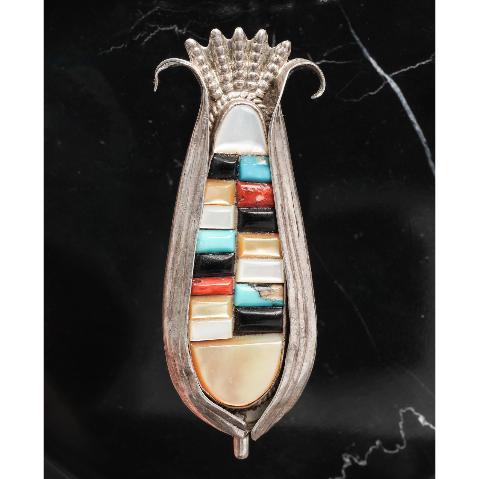 Vintage Zuni Sterling Silver Maize Inlay Pendant Signed: Vintage Zuni Sterling Silver Maize Inlay Pendant SignedCirca 1970s, USASterling silver pendant in the form of a maize (corn) ear, featuring a colorful geometric inlay design with turquoise, coral, jet