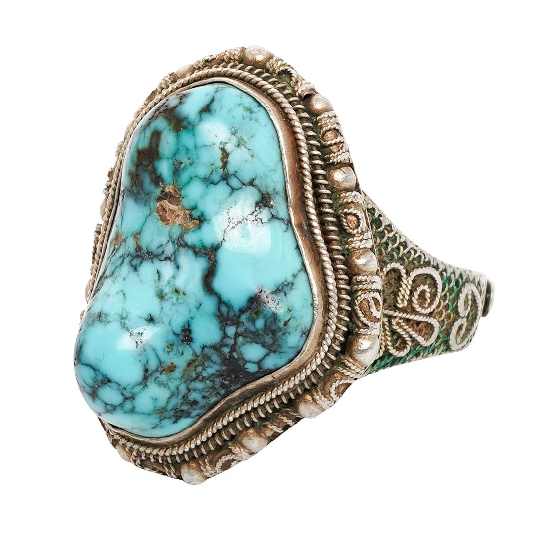 Antique Chinese Silver & Turquoise Ring: Antique Chinese Silver & Turquoise RingCirca 1910-1940, ChinaAntique Chinese export silver ring set with a freeform cabochon natural turquoise measuring approximately 20 × 14 mm, displaying vivid blu