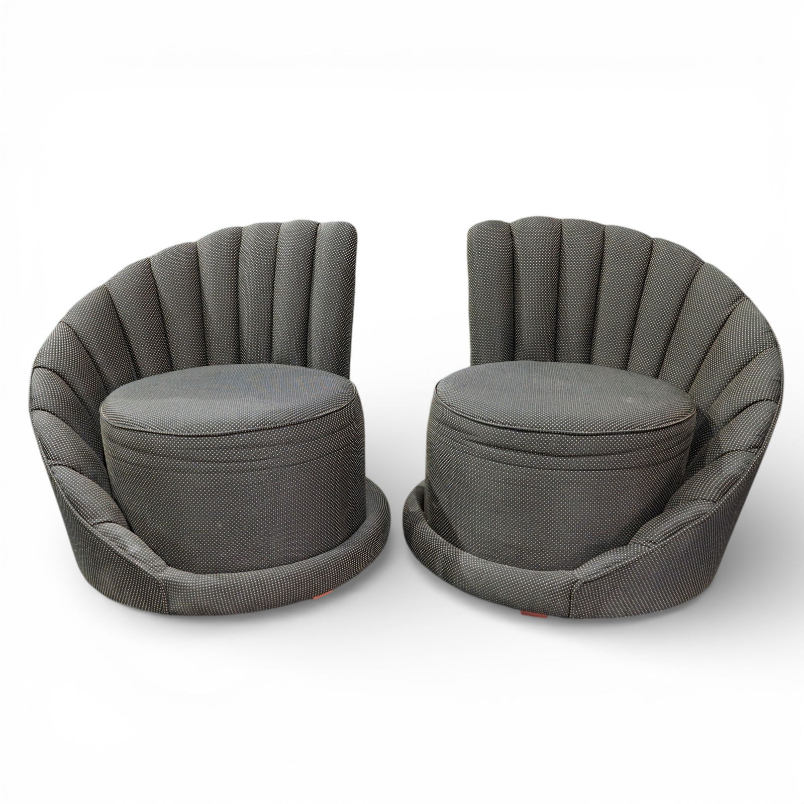 Pair Mid Century Lounge Chairs: Pair Mid Century Lounge Chairs Mid 20th Cent. The chair has a low, rounded form with a scalloped, channel-tufted backrest that curves inward, creating an enveloping seat. It is fully upholstered in a