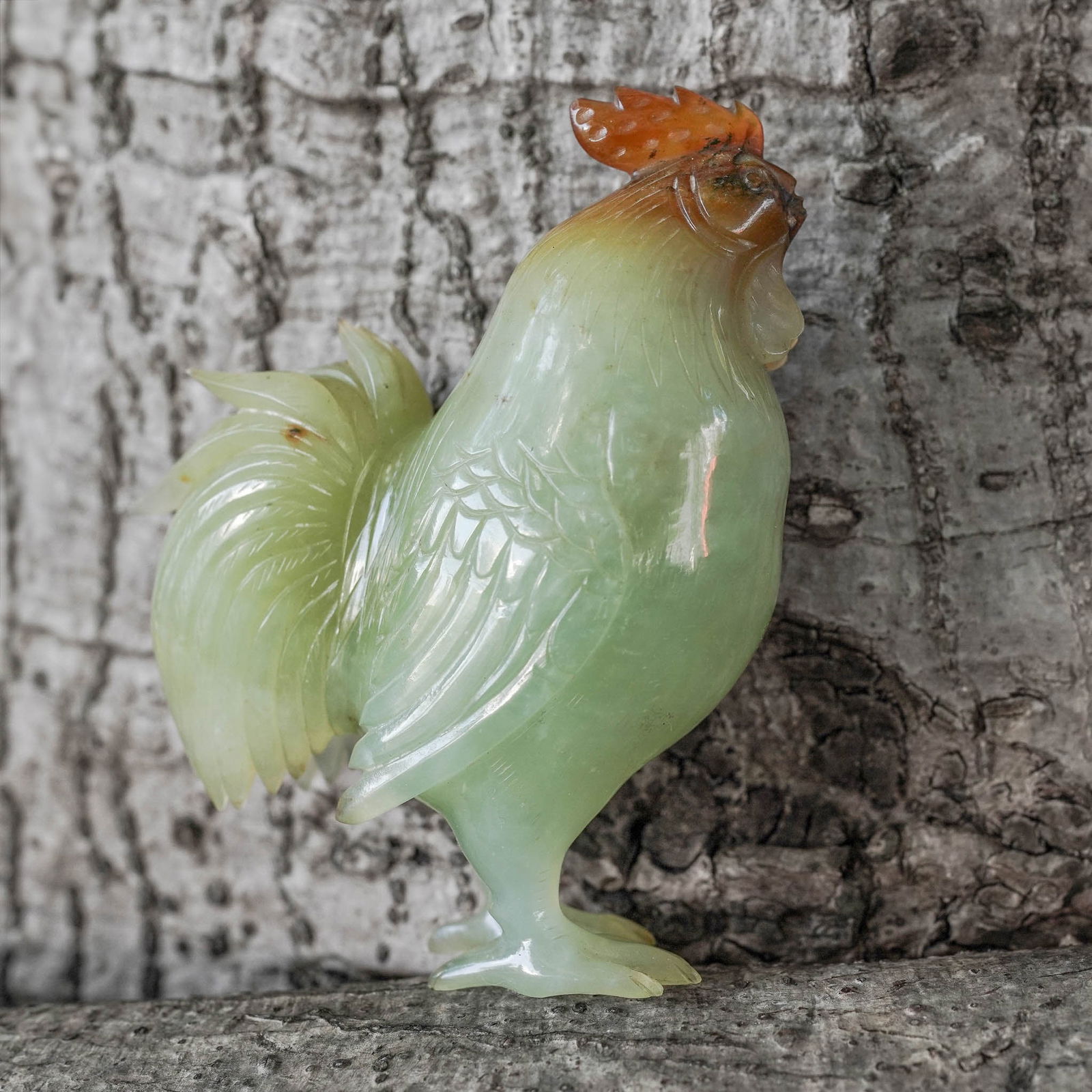 Chinese Carved Jade Rooster Figurine: Chinese Carved Jade Rooster Figurine Early-Mid 20th c., China Hand-carved natural jade rooster figure featuring highly detailed textured feathers. H: 4.25" W: 1.5" L: 4"