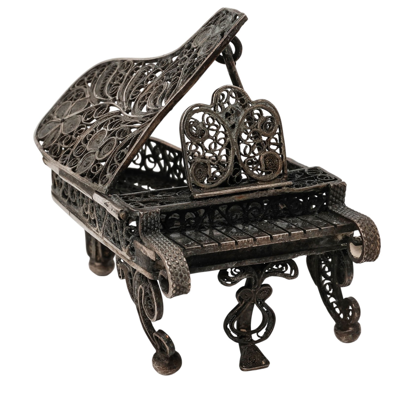 Antique Silver Filigree Miniature Piano: Antique Silver Filigree Miniature Piano Late 19th-early 20th century, European Antique silver filigree miniature grand piano. It features elaborate floral and scroll patterns with rolled armrests.