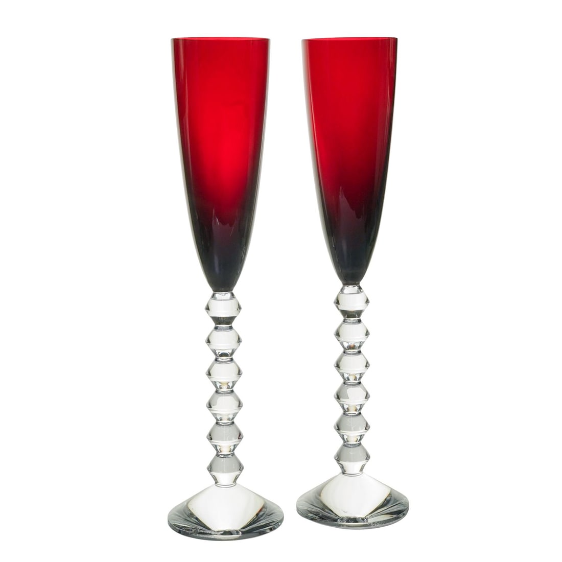 Pair Baccarat "Vega" Red Champagne Flutes: Pair Baccarat "Vega" Red Champagne Flutes20th century, FrenchDesigned by Savinel & Roze, featuring a distinctive sculpted zigzag stem with stacked diamond-cut shapes. Marked on the base. Comes in orig