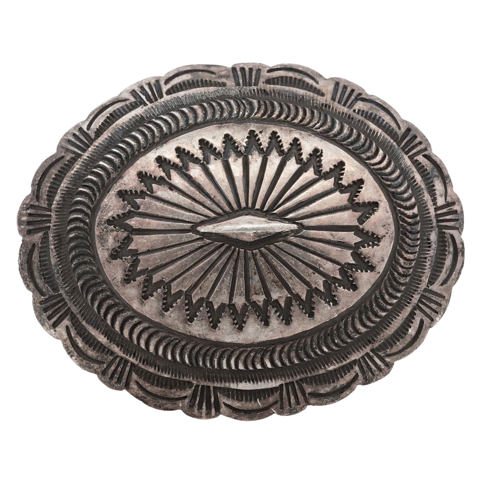 Vintage Navajo Sterling Silver Stamped Oval Belt Buckle: Vintage Navajo Sterling Silver Stamped Oval Belt Buckle Circa 1960s1970s, American Vintage Navajo oval sterling silver belt buckle decorated with dense hand-stamped radiating motifs centered by a