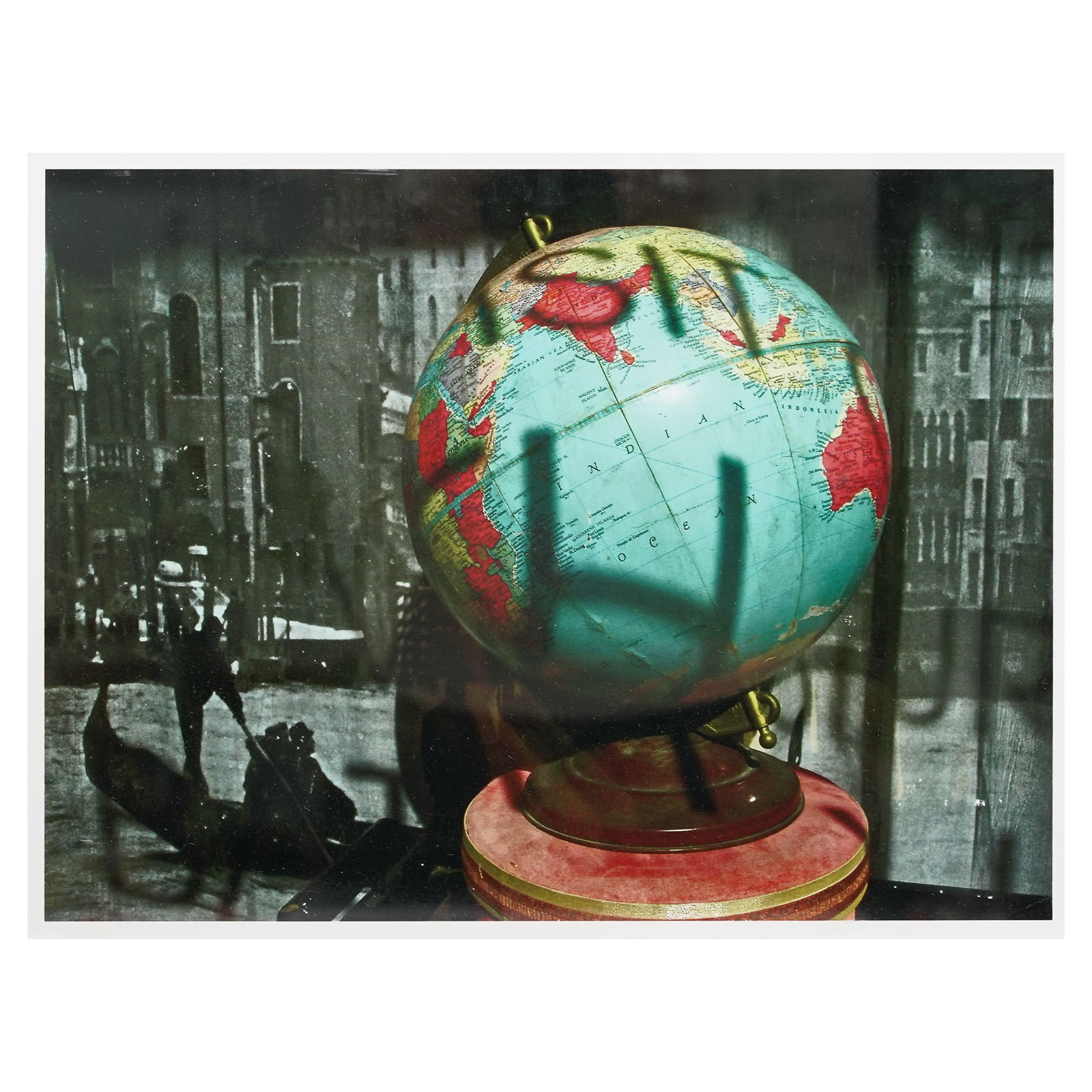 Color Gel Globe Photographic Print: Color Gel Globe Photographic Print20th centuryAn unsigned color gel print of a globe with a historical photograph, likely Venice, in the background. Black frame. Framing label affixed to back.Frame H