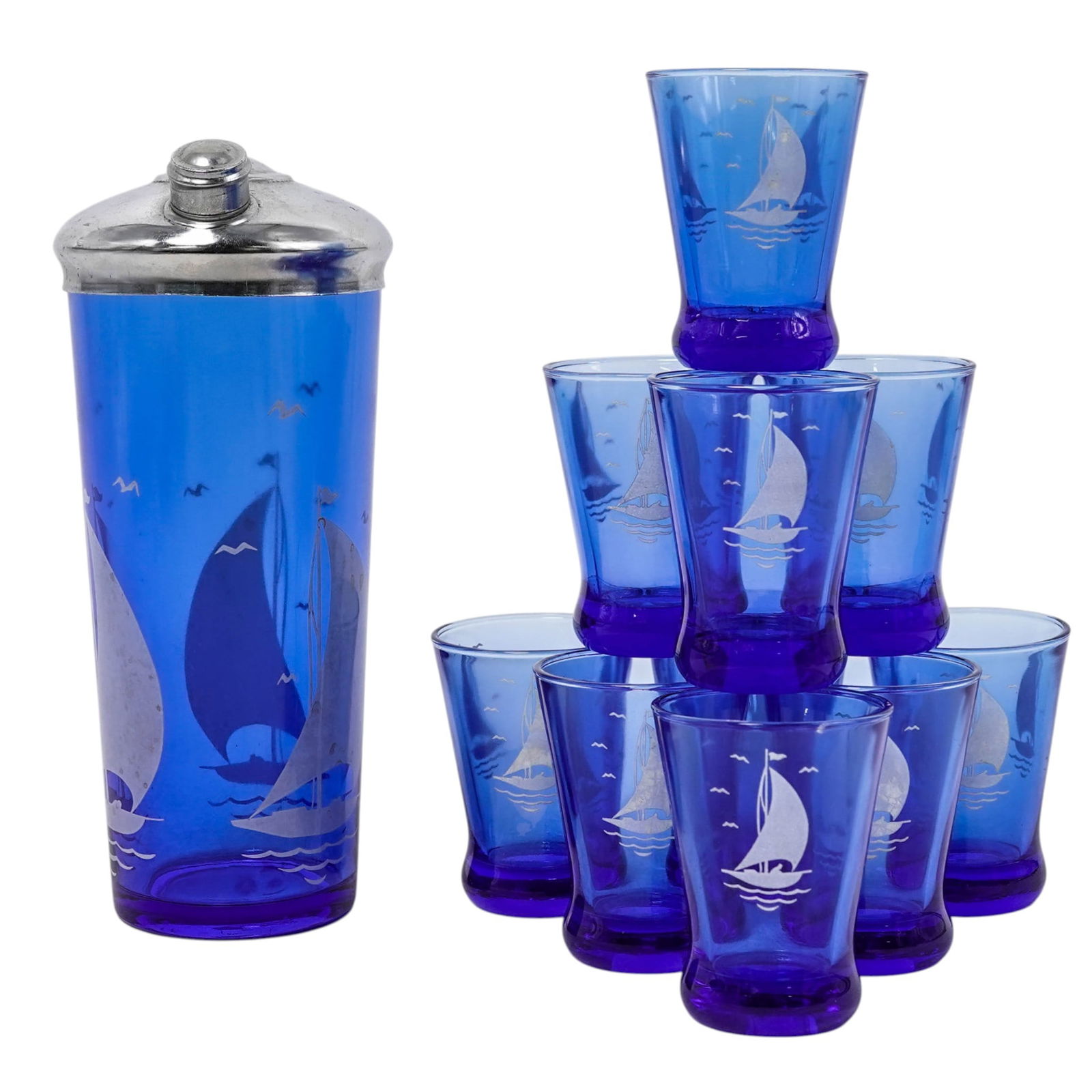 (11pc) Art Deco Hazel-Atlas Sportsmans Glass Cocktail Set: (11pc) Art Deco Hazel-Atlas Sportsmans Glass Cocktail Set 1930. American The set is crafted from vibrant cobalt blue glass and features a distinctive white fired-on sailboat and seagull pattern. The