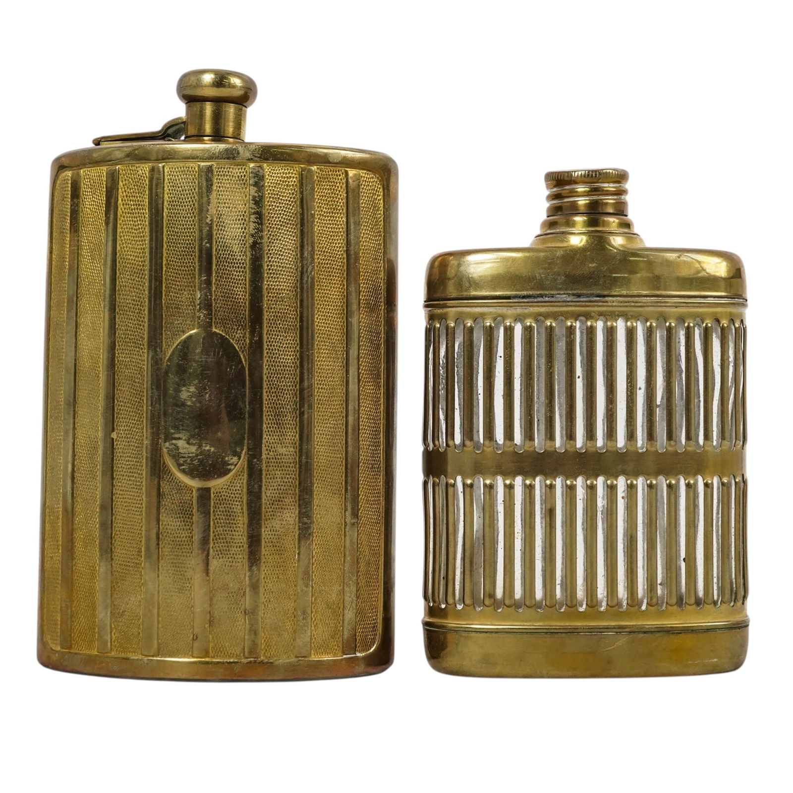 (2 Pc) Antique Brass Hip Flasks: (2 Pc) Antique Brass Hip Flasks c. 1920s, USA (1) Brass-plated caged glass hip flask with a screw top lid. (1) Brass hip flask with a hinged screw top lid featuring a vertical engine-turned stripe