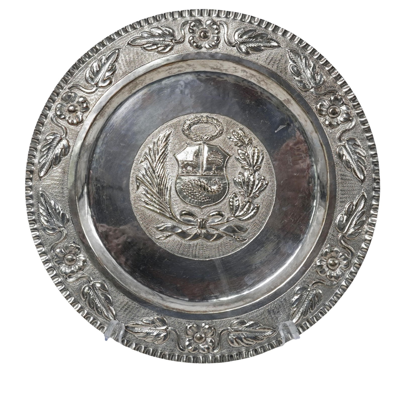 Welsch Amano Sterling Peruvian Coat of Arms Decorative Plate: Welsch Amano Sterling Peruvian Coat of Arms Decorative Plate 20th century, Peruvian Peruvian sterling silver repousse decorative plate with the national Coat of Arms in the center and a floral
