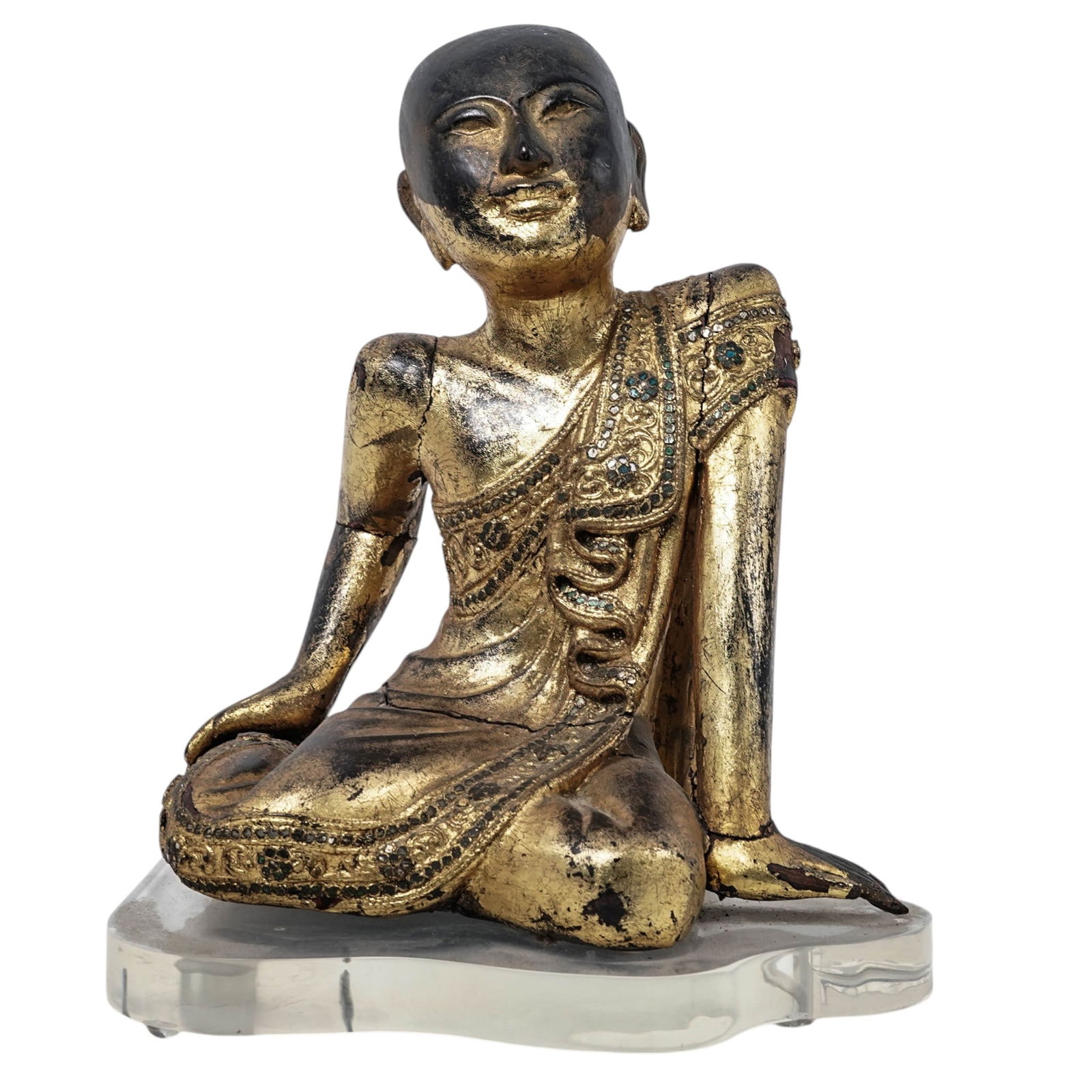 Burmese Gilded Wood Monk Statue: Burmese Gilded Wood Monk StatueEarly 20th Century. Southeast AsiaSculpture of Buddhist monk in contemplation, crafted in polychrome wood and enhanced with inclusions of small glass insets on his robe.