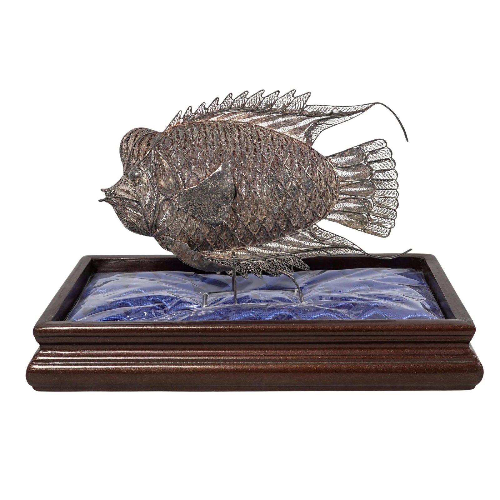 Silver Filigree Flowerhorn Cichlid Fish Display: Silver Filigree Flowerhorn Cichlid Fish DisplayLate 20th centuryFlowerhorn Cichlid fish sculpture crafted from intricate silver filigree work on a wooden base with a blue satin cushion.Weight: Approx.