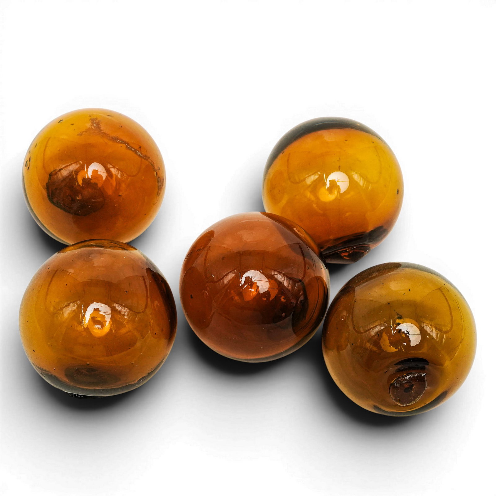(5 Pc) Amber Glass Orbs: (5 Pc) Amber Glass Orbs Likely Early - Mid 20th Century, Origin Unknown Set of five amber glass orbs featuring smooth, polished surfaces and rich golden-brown tones. Each orb is individually crafted