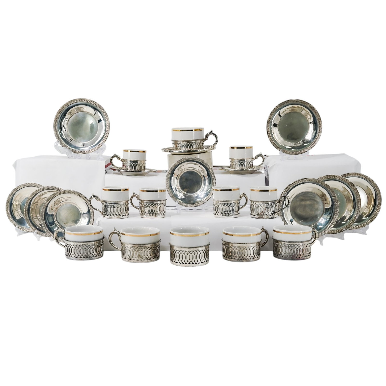 (36 pcs) Camusso Sterling Holders, Saucers w/ Porcelain Inserts: (36 pcs) Camusso Sterling Holders, Saucers w/ Porcelain Inserts 20th century Camusso sterling silver coffee or tea cup handled holders featuring a pierced open work design with porcelain inserts and