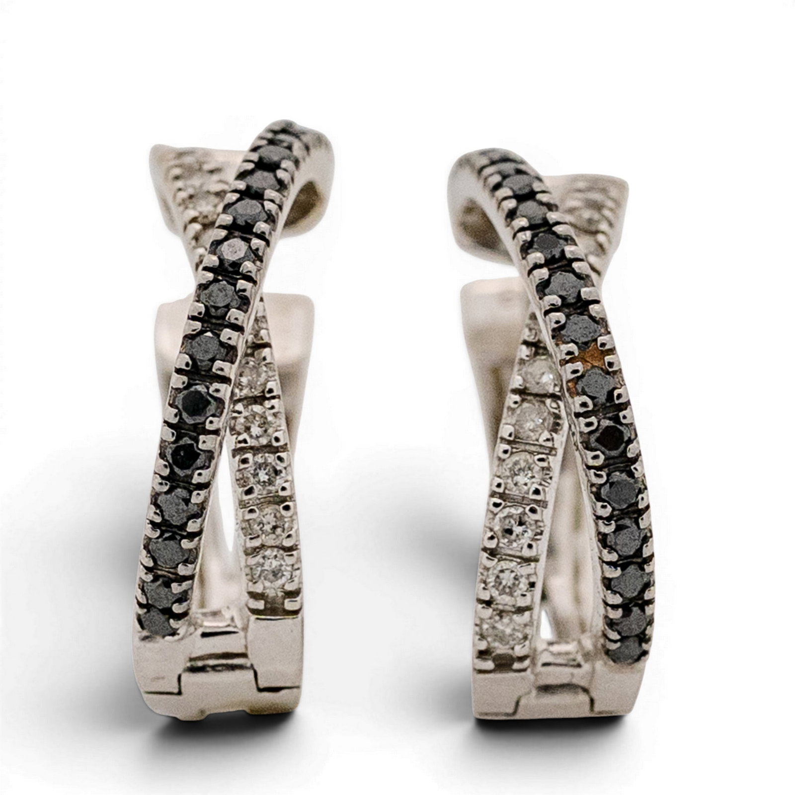 14k Gold & Black and White Diamond Hoop Earrings: 14k Gold & Black and White Diamond Hoop Earrings Late 20th Century 14k white gold hoop earrings designed with crossover rows of round black and white diamonds totaling approximately 0.80 carats. Stamp