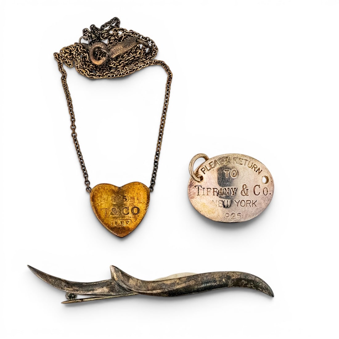 Tiffany & Co. Sterling Silver Charm & Angela Cummings Brooch Lot: Tiffany & Co. Sterling Silver Charm & Angela Cummings Brooch Lot Late 20th Century, USA Mixed sterling silver jewelry lot including a Tiffany & Co. “1837” heart necklace stamped “925,”