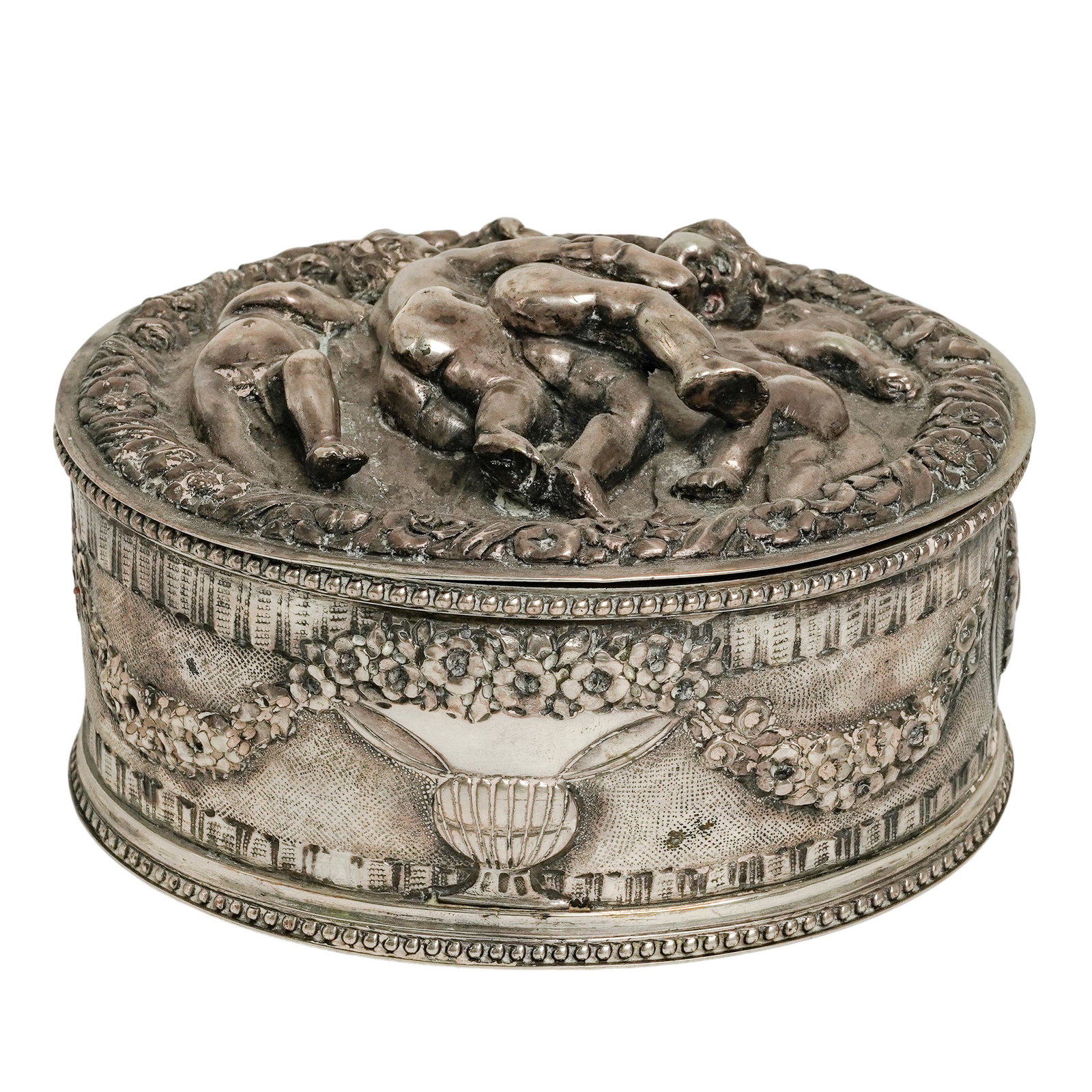 Vintage Silver & Bronze Relief Cherubs Box: Vintage Silver & Bronze Relief Cherubs Box 20th Century, Continental. Vintage Silver & Bronze Relief Cherub Box. Oval decorative box featuring high-relief cherub motifs to the lid and body with