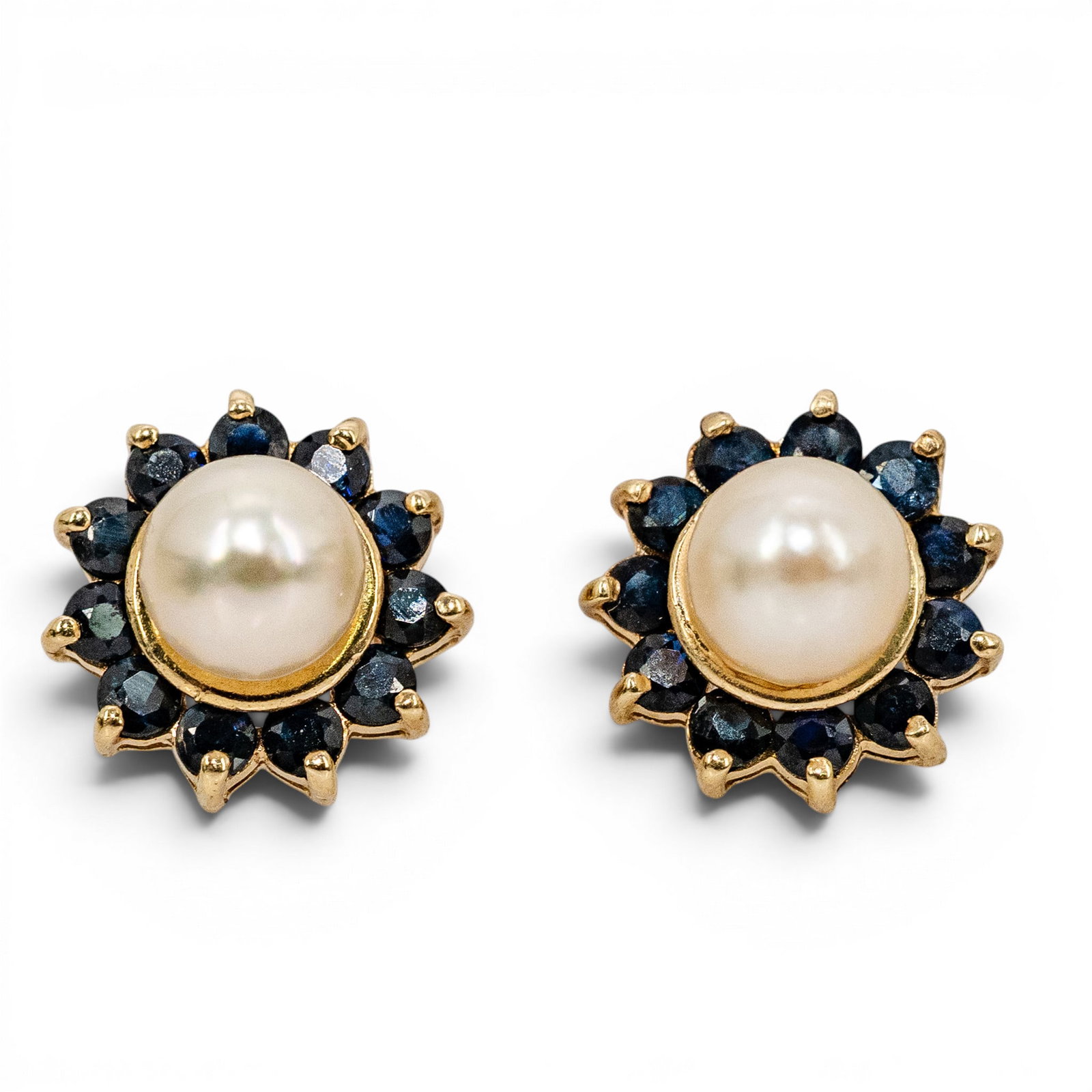 JCM 14k Gold Pearl & Sapphire Cluster Stud Earrings: JCM 14k Gold Pearl & Sapphire Cluster Stud Earrings 1990s, USA Pair of 14k yellow gold stud earrings by JCM, each set with a central cultured pearl measuring approximately 5.6mm, surrounded by a halo 
