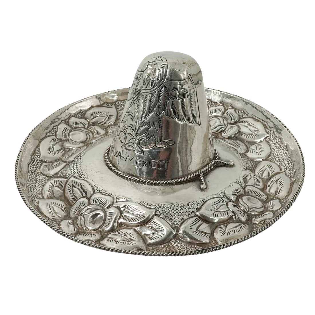 Mexican Sterling Silver Mexico Sombrero: Mexican Sterling Silver Mexico Sombrero Late 20th Century, Mexico. Mexican Sterling Silver Sombrero Form Cup and Saucer, the hat-shaped cup raised on a circular dish with repoussé floral decoration a