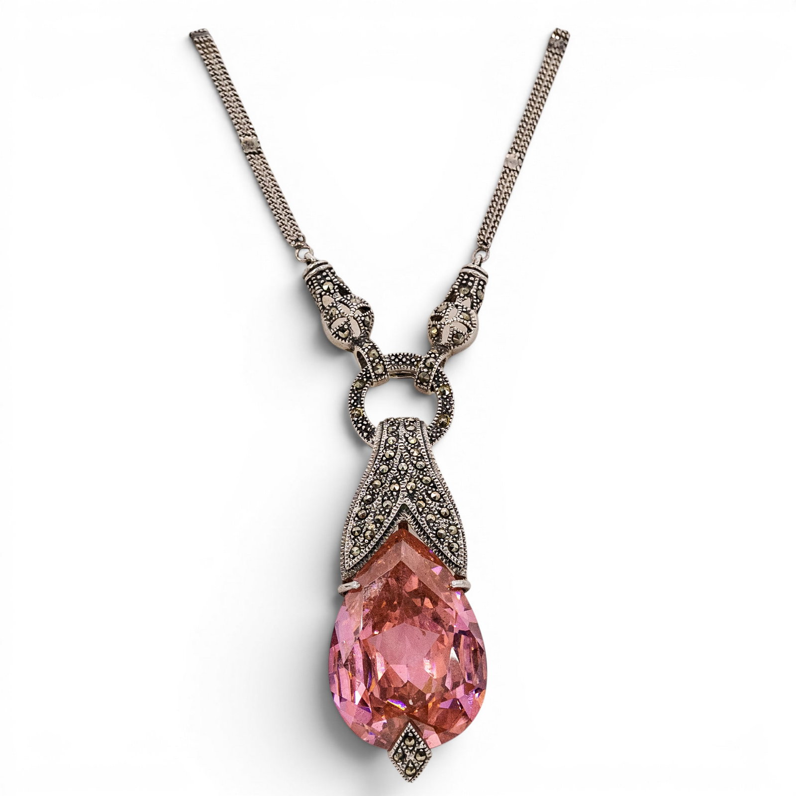 Sterling Silver Marcasite & Pink Glass Pendant Necklace: Sterling Silver Marcasite & Pink Glass Pendant Necklace Late 20th Century Sterling silver pendant necklace featuring a large faceted pear-shaped pink glass stone accented by marcasite in an ornate Art